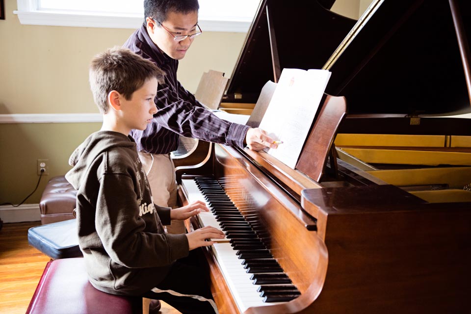 Akira teaching piano lesson to a student